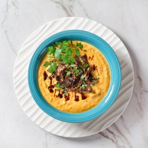Pumpkin soup with wild mushrooms on a blue bowl